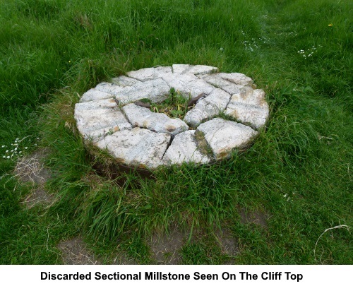A discarded sectional millstone seen on the cliff tops.